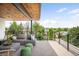 A covered patio with a sectional sofa, green ottomans and views of trees and blue sky at 2926 S Cherokee St, Englewood, CO 80110