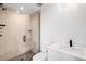 Modern bathroom features a glass shower, neutral textured tile, and sleek black hardware at 2926 S Cherokee St, Englewood, CO 80110