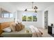 Bedroom featuring a large window, stylish light fixture, and a comfortable bed with soft textures at 2926 S Cherokee St, Englewood, CO 80110