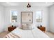 Bright bedroom featuring white walls, wood nightstands, and natural light from the two windows at 2926 S Cherokee St, Englewood, CO 80110