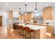 Modern kitchen featuring an island with seating, stainless appliances, and hardwood floors at 2926 S Cherokee St, Englewood, CO 80110