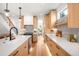 Modern kitchen featuring light wood cabinetry, stainless steel appliances, and a breakfast bar with pendant lighting at 2926 S Cherokee St, Englewood, CO 80110