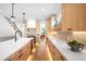 Bright kitchen boasts modern appliances, light wood cabinets, white countertops, and an island with a sink at 2926 S Cherokee St, Englewood, CO 80110