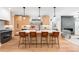 Modern kitchen featuring an island with seating, stainless appliances, and hardwood floors at 2926 S Cherokee St, Englewood, CO 80110