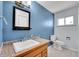 Bathroom featuring blue walls, modern sink, granite countertop, and toilet adjacent to the window at 414 S Nelson S St, Lakewood, CO 80226