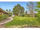 This backyard is complete with lush green lawn and mature trees at 7901 E Kenyon Dr, Denver, CO 80237