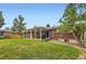 A verdant backyard with an outdoor patio, lush lawn, and mature trees creates a private outdoor oasis at 7901 E Kenyon Dr, Denver, CO 80237