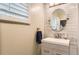 Contemporary bathroom with round mirror, tiled wall and a sleek modern vanity at 7901 E Kenyon Dr, Denver, CO 80237