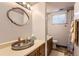 This bathroom features a vanity, mirror with decorative light fixture, and a toilet with a window for natural light at 7901 E Kenyon Dr, Denver, CO 80237