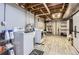 A functional laundry room with white washer, dryer, modern cabinets, and exposed ductwork at 7901 E Kenyon Dr, Denver, CO 80237