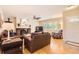 Bright living room featuring hardwood floors, brick fireplace, and plantation shutters on the windows at 7901 E Kenyon Dr, Denver, CO 80237