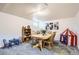 A spacious living room that is complete with a wooden table, six chairs, decor, carpeted floors, and a small tent at 7901 E Kenyon Dr, Denver, CO 80237