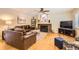 Cozy living room with hardwood floors, a brick fireplace, and a comfortable leather sofa at 7901 E Kenyon Dr, Denver, CO 80237