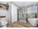 Bathroom with walk-in shower, freestanding bathtub, and wood-look flooring at 12660 Jersey W Cir, Thornton, CO 80602