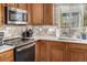 Kitchen corner with stainless steel appliances and wood cabinets at 12660 Jersey W Cir, Thornton, CO 80602