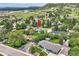 Aerial view of a home surrounded by lush trees in a peaceful neighborhood with nearby mountains at 1100 E Harvey St, Castle Rock, CO 80108