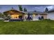 An expansive backyard with a covered patio, outdoor dining, a grill, and a large grassy area at 1100 E Harvey St, Castle Rock, CO 80108