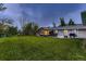 A spacious backyard featuring a covered patio, outdoor seating, a grill, and a lush green lawn at 1100 E Harvey St, Castle Rock, CO 80108