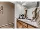 Well-lit bathroom with a wide mirror, wood vanity, and natural lighting at 1100 E Harvey St, Castle Rock, CO 80108