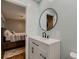 Light and airy bathroom with a white vanity and a round mirror, next to a bedroom at 1100 E Harvey St, Castle Rock, CO 80108