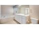 Bright bathroom featuring a soaking tub, double vanity, and shuttered window at 13806 E Chenango Dr, Aurora, CO 80015