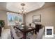 Formal dining room with a dark wood table, upholstered chairs, and a decorative chandelier at 13806 E Chenango Dr, Aurora, CO 80015