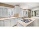 Bright kitchen features white cabinets, a center island cooktop, and a garden view at 13806 E Chenango Dr, Aurora, CO 80015