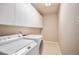Bright laundry room with washer, dryer, and ample white cabinet storage at 13806 E Chenango Dr, Aurora, CO 80015