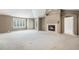 Spacious living room featuring neutral tones, a fireplace, and large windows with plantation shutters at 13806 E Chenango Dr, Aurora, CO 80015