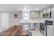 Bright kitchen with stainless steel appliances, a modern countertop, and a wooden dining table at 14701 E Colfax Ave # A5, Aurora, CO 80011