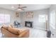 Living room with a contemporary electric fireplace, a modern chair, and bright natural light at 14701 E Colfax Ave # A5, Aurora, CO 80011