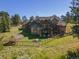 Aerial view of house, yard, and greenhouse with mountain backdrop at 1138 County Road 65, Evergreen, CO 80439