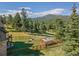 Landscaped backyard with greenhouse, play area, and mountain views at 1138 County Road 65, Evergreen, CO 80439