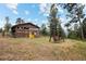 Rustic guest house with yellow door and mountain backdrop at 1138 County Road 65, Evergreen, CO 80439