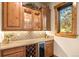 Convenient wet bar with wine cooler, granite countertop, and glass-front cabinets at 1138 County Road 65, Evergreen, CO 80439