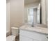 Well-lit bathroom with a modern vanity, stone countertop, and a large mirror reflecting natural light from the doorway at 48290 Shetland Dr, Bennett, CO 80102