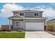 Charming two-story home featuring a gray exterior, attached two-car garage, and a well-maintained lawn and landscaping at 48290 Shetland Dr, Bennett, CO 80102
