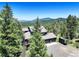 Aerial view of home with a lush green forest and distant mountain range at 30889 Manitoba Dr, Evergreen, CO 80439