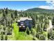 Lovely backyard with a large deck, lush greenery, and scenic views of the mountains at 30889 Manitoba Dr, Evergreen, CO 80439