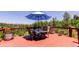Outdoor deck with an umbrella-covered dining table and chairs overlooking a lush, green landscape at 30889 Manitoba Dr, Evergreen, CO 80439