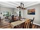 Open-concept dining area flowing into the living room with hardwood floors and natural lighting at 30889 Manitoba Dr, Evergreen, CO 80439