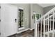 Bright entryway with a white front door and staircase, offering a glimpse of the outdoors at 30889 Manitoba Dr, Evergreen, CO 80439