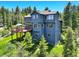 Stunning exterior view of a two story home with a spacious deck and wooded landscape at 30889 Manitoba Dr, Evergreen, CO 80439