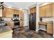 Well-lit kitchen with stainless steel appliances, light wood cabinets, and durable tile flooring at 30889 Manitoba Dr, Evergreen, CO 80439
