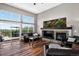 Bright living room with high ceilings, large windows, a fireplace, and access to a spacious outdoor deck at 30889 Manitoba Dr, Evergreen, CO 80439