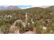 Picturesque aerial view of a home surrounded by dense forest and winding roads at 29857 Park Village Dr, Evergreen, CO 80439