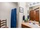Split bathroom with enclosed shower-tub, a white sink and vanity, and nautical decor at 29857 Park Village Dr, Evergreen, CO 80439