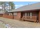 Back of a charming brown home with a small wooden deck and a well-maintained lawn at 29857 Park Village Dr, Evergreen, CO 80439