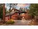Stunning wood home with a deck, mature trees, stone accents, and a long driveway at 29857 Park Village Dr, Evergreen, CO 80439