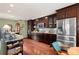 Gourmet kitchen with stainless steel refrigerator, dark wood cabinets and backsplash at 29857 Park Village Dr, Evergreen, CO 80439